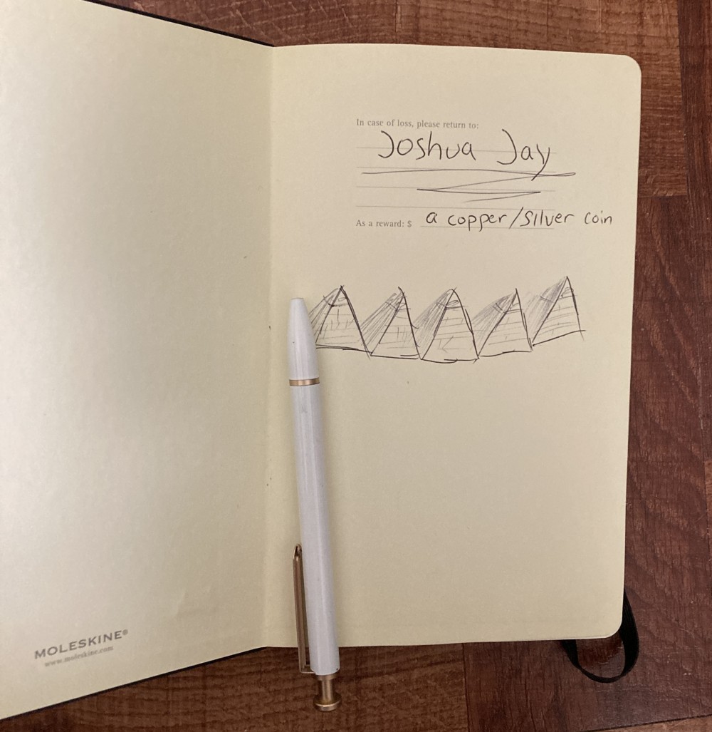 photo of notebook title page that has the name Joshua Jay written on with along with doodles of pyramids